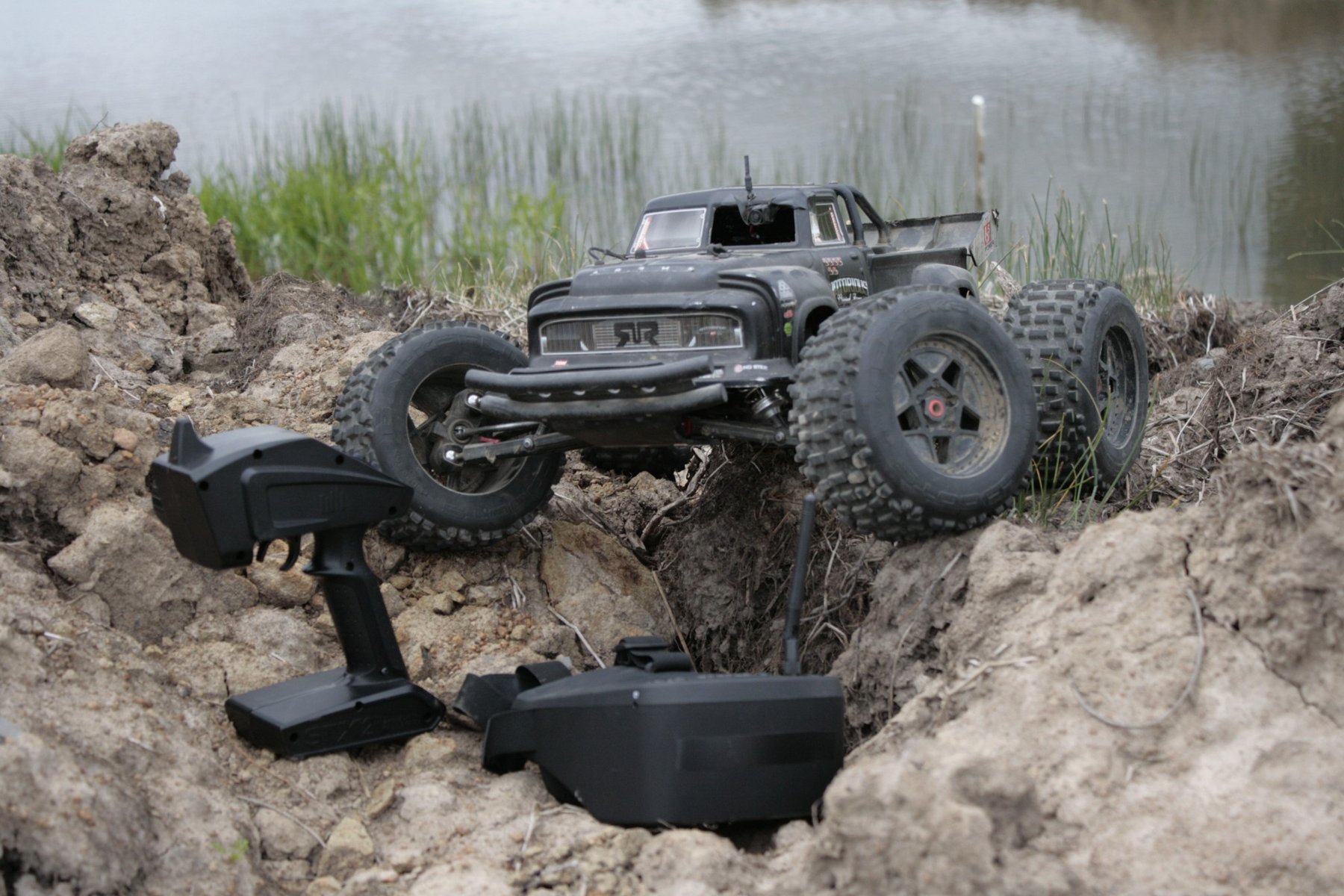 Actual RC off-road truck and controller on grassy terrain